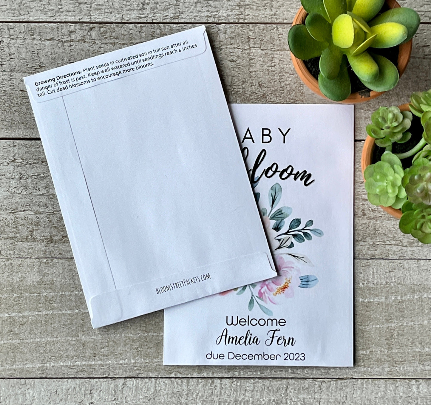 Two white seed packets, one with flowers on the front, the other showing the back of the packet.